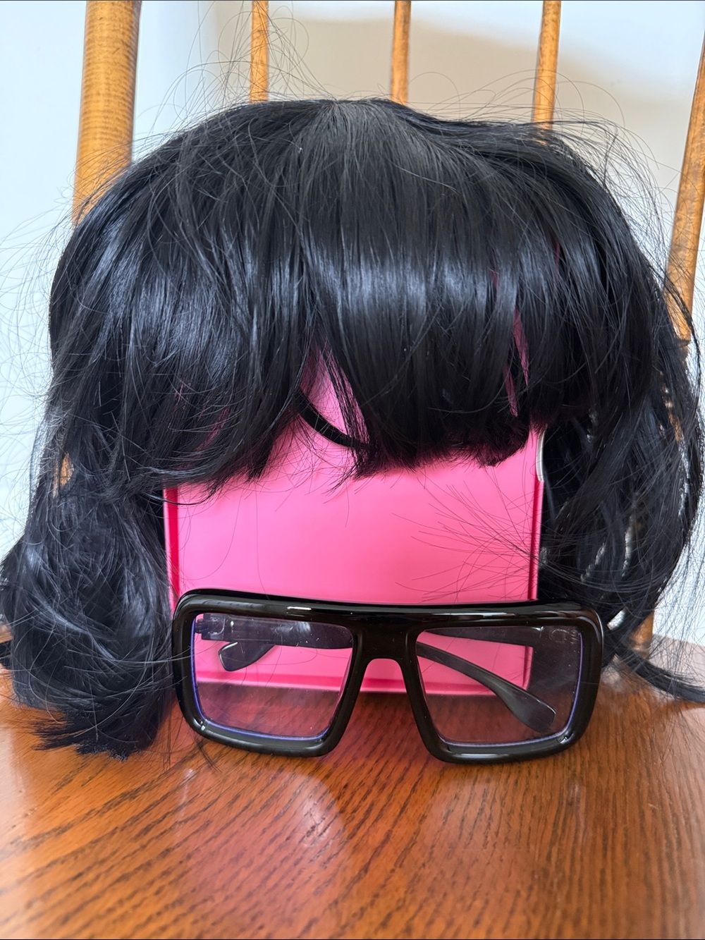 Black short wig and black wide rimmed glasses.
